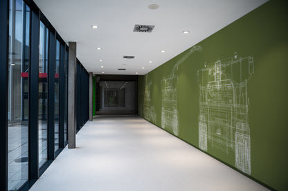 Corridor with green wall featuring CLAAS technical drawings