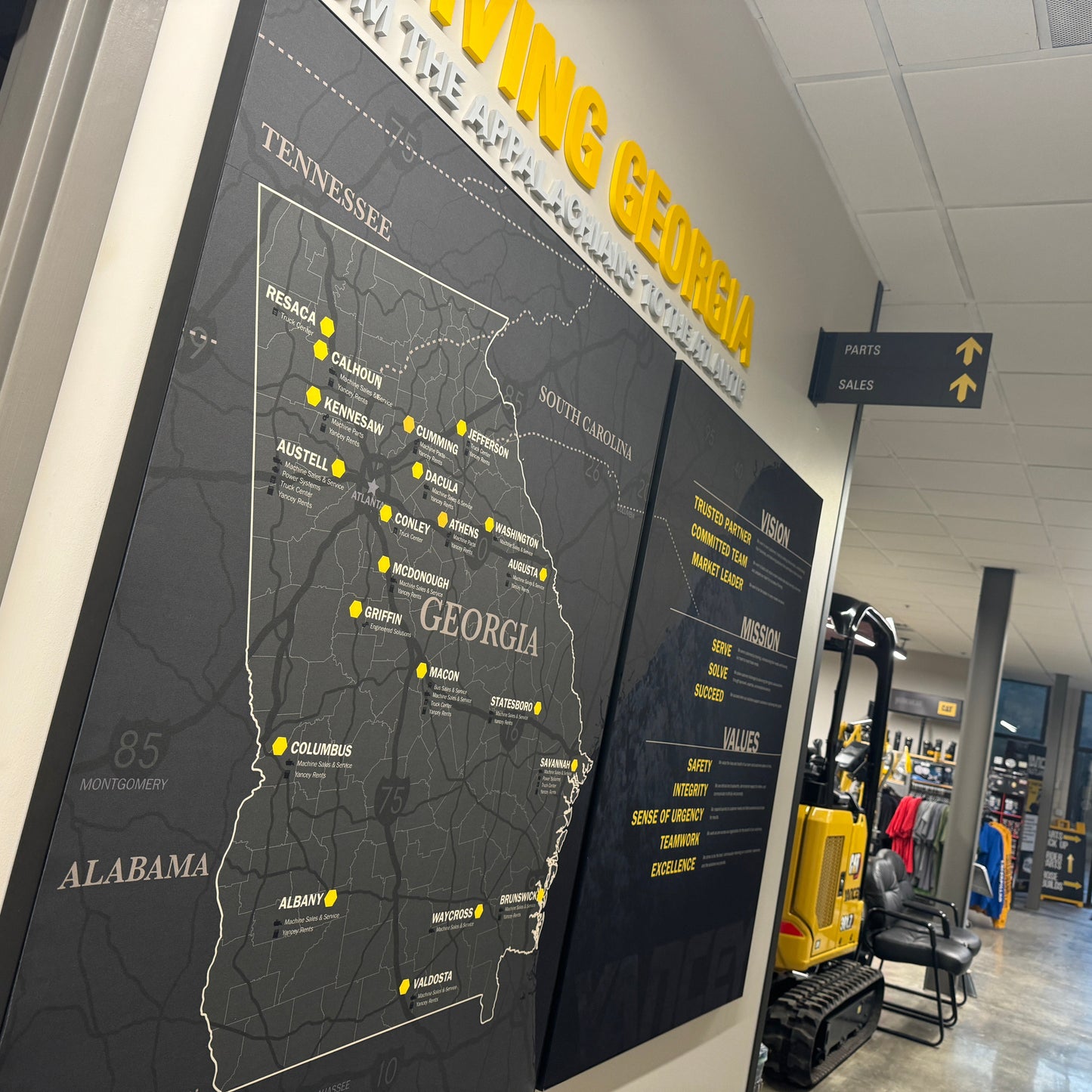 Territory Map for Caterpillar Dealer Showroom on a wall with 'Serving Georgia' text above it, in an indoor setting.