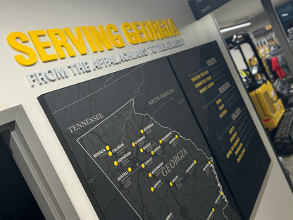 Territory Map for Caterpillar Dealer Showroom on a wall with 'Serving Georgia' text above it, in an indoor setting.