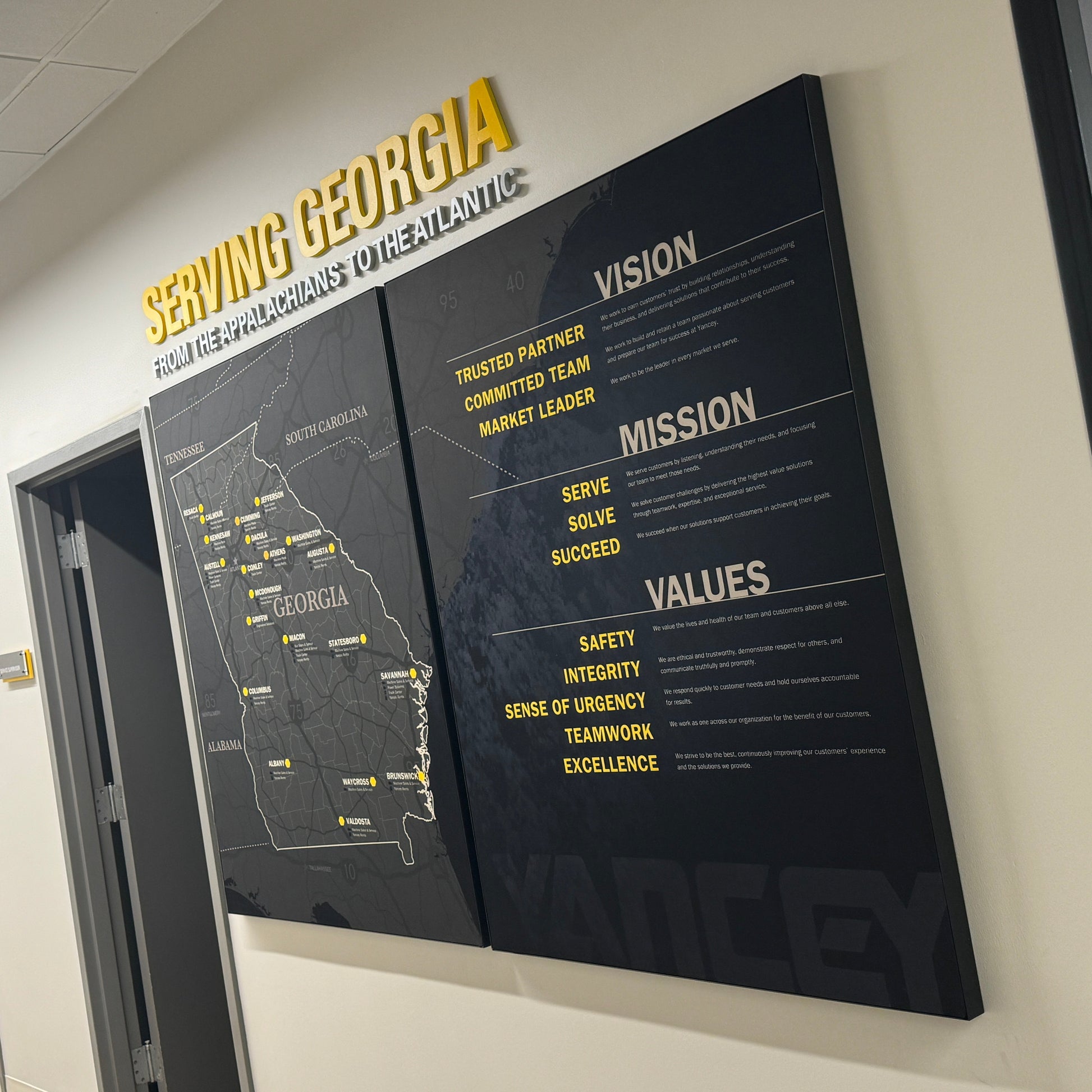 Territory Map for Caterpillar Dealer Showroom on a wall with 'Serving Georgia' text above it, in an indoor setting.
