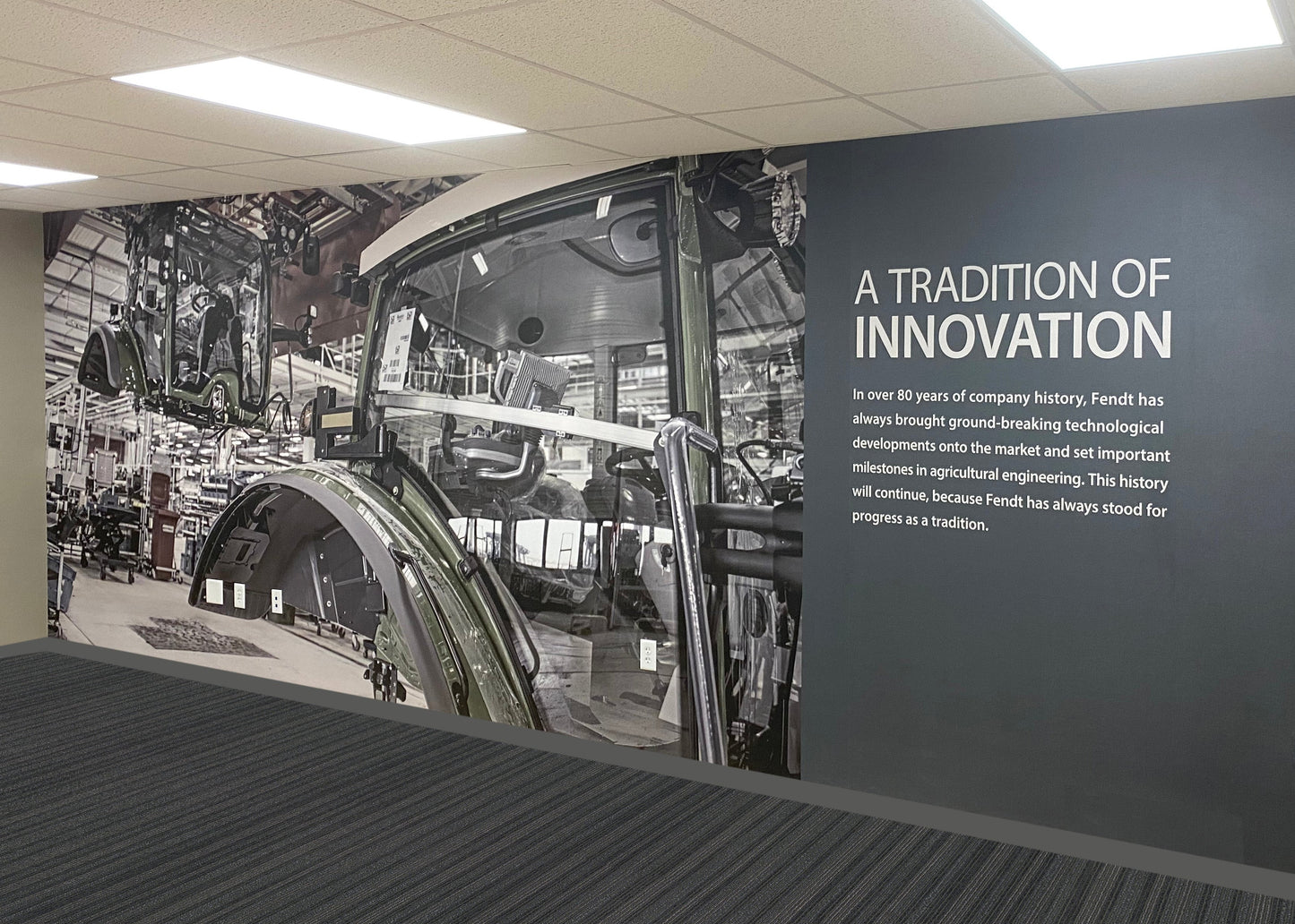 Wall with industrial-themed mural and text about innovation in a modern setting