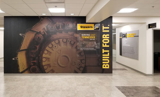 A wall mural featuring a close-up of a CAT undercarriage.